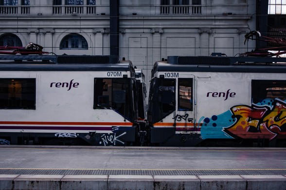 Two Renfe 470 EMUs with Renfe's MD livery coupled together. The trains are mostly white, with a black roof and two orange and purple stripes below the windows.