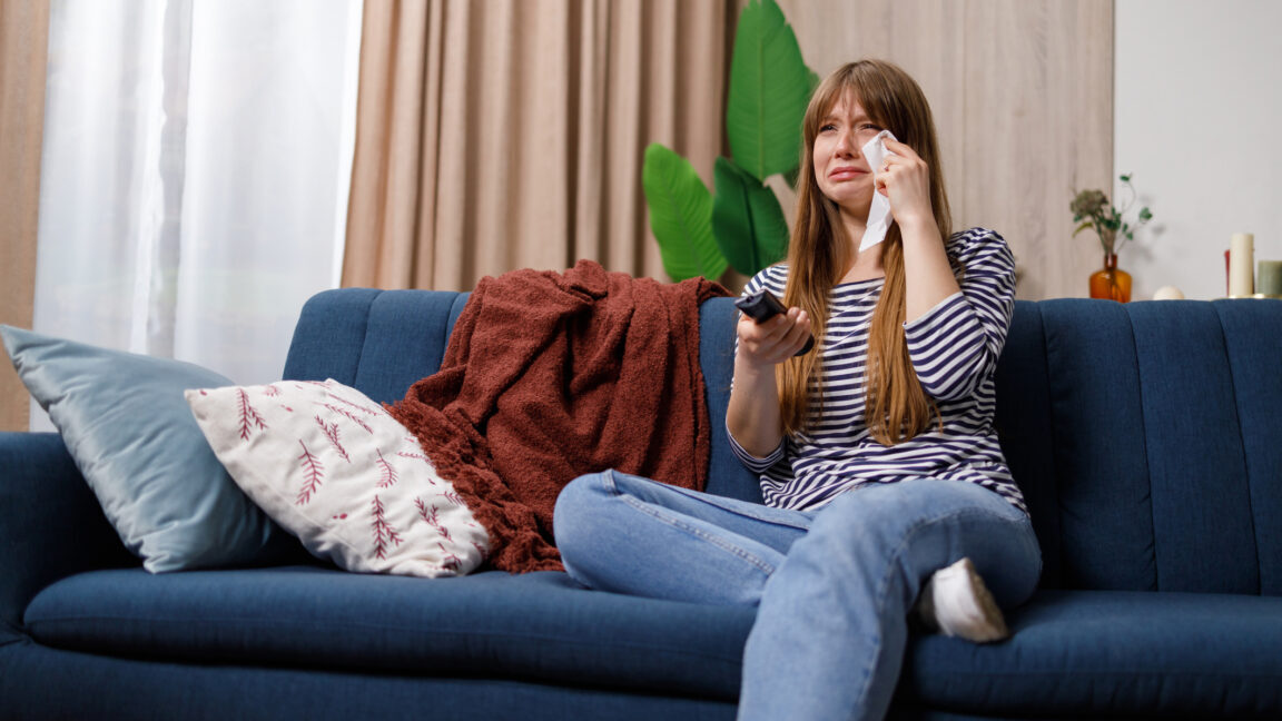 woman watching television and crying